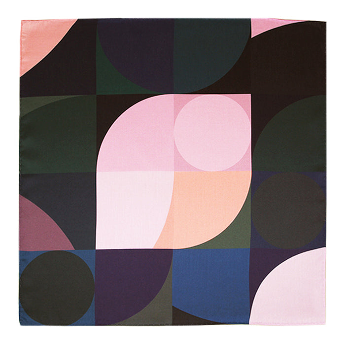 A square cotton handkerchief laid flat showing an abstract geometric pattern in pink, navy, green, and peach.