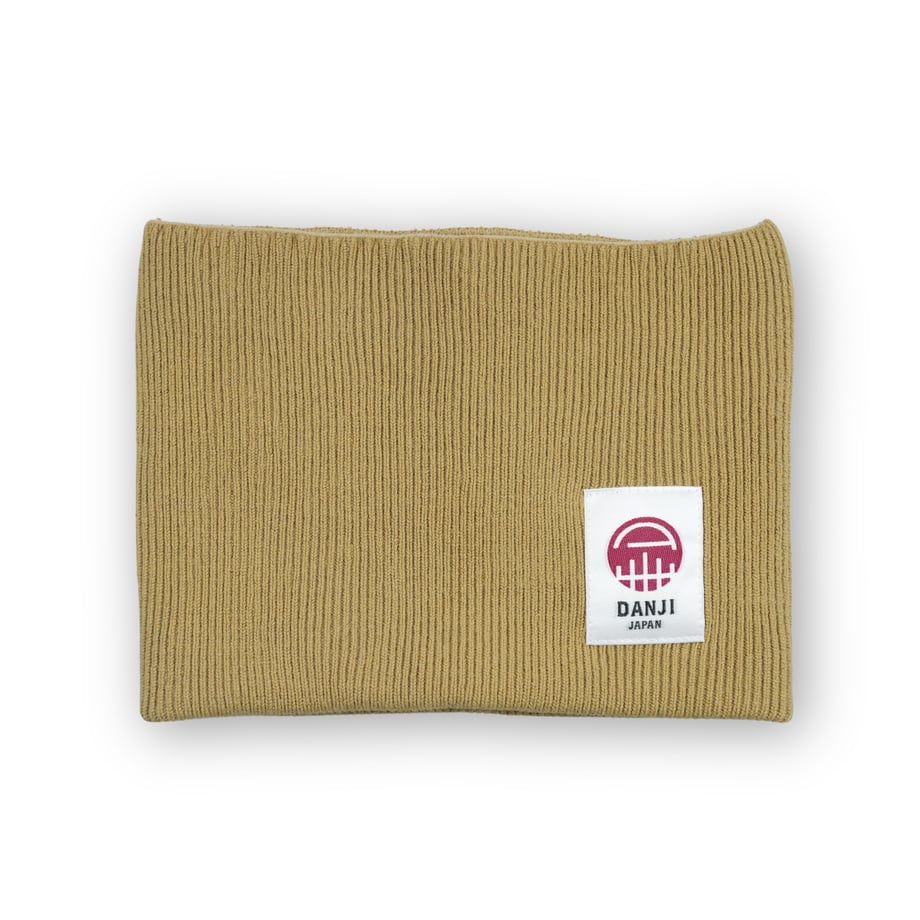 Folded beige ribbed cotton stomach warmer showing a white brand patch.