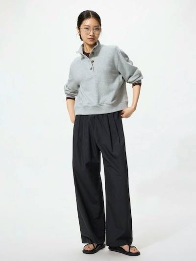 Model wearing long black wide-leg women's cotton pants paired with a gray pullover.
