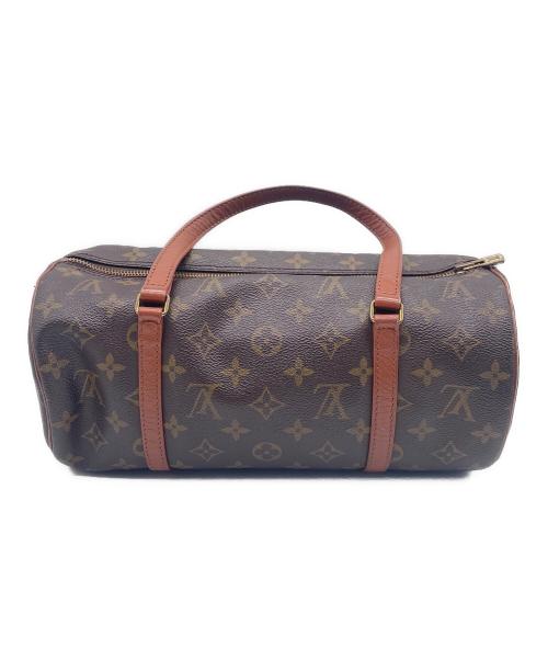Cylindrical brown monogram-pattern handbag with leather handles on a white background.