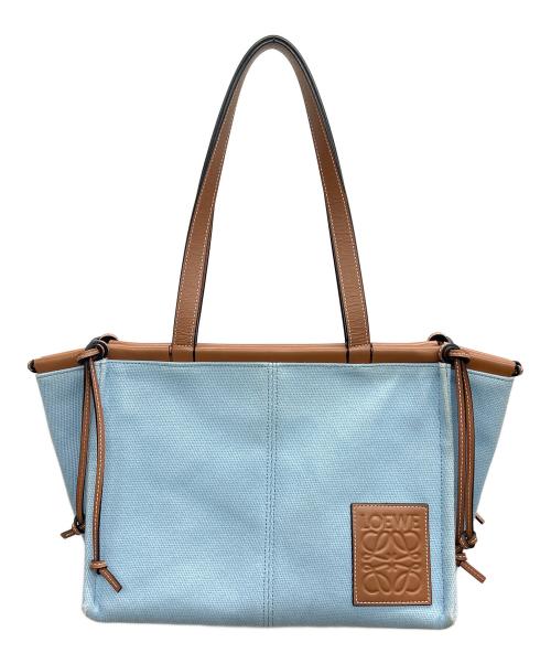 Light blue tote bag with brown leather handles, trim, and a square leather patch on the front.