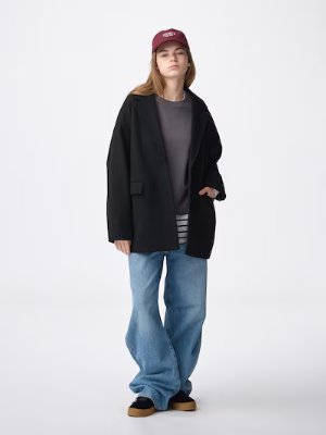 Female model wearing the women's polyester half coat in black, shown full-length.