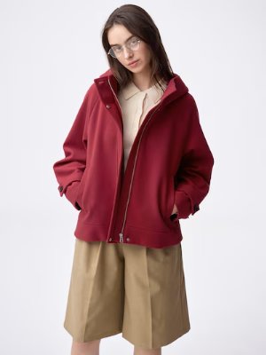 Model wearing the Cozy melton short hoodie coat in red with hands in pockets.