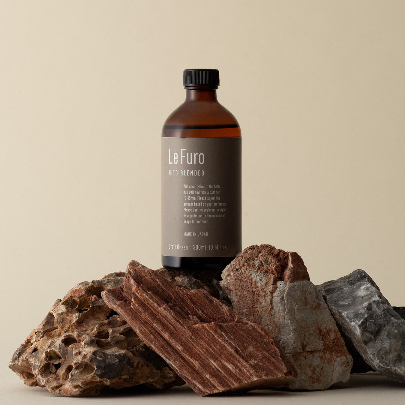 A brown 300ml bottle of bath liquid labeled "LeFuro" displayed on rocks against a neutral background.
