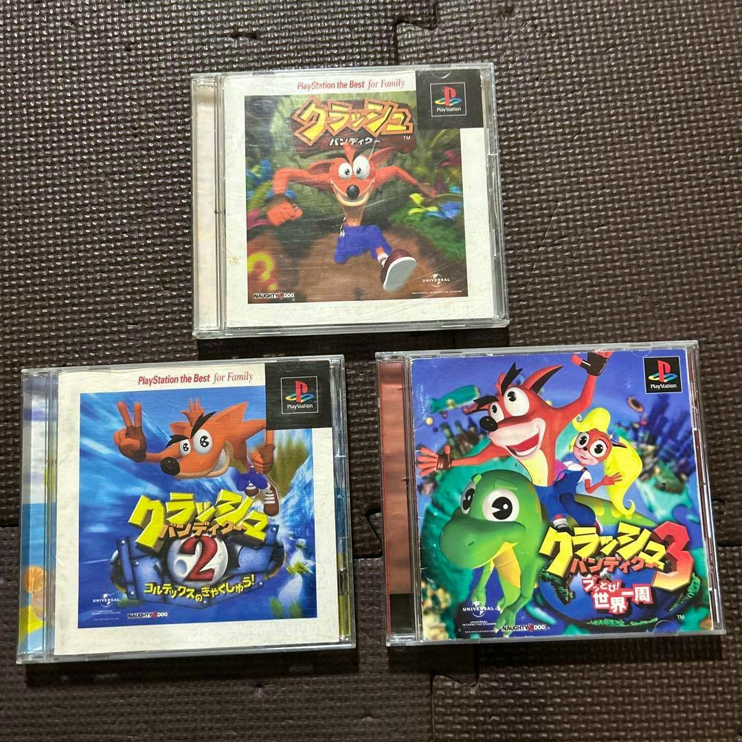 Three PlayStation jewel-case game covers for Crash Bandicoot 1, 2, and 3 displayed on a dark textured surface showing the front artwork.