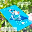 A green cream-soda "mendako-chan" plastic keychain displayed on a blue backing card.