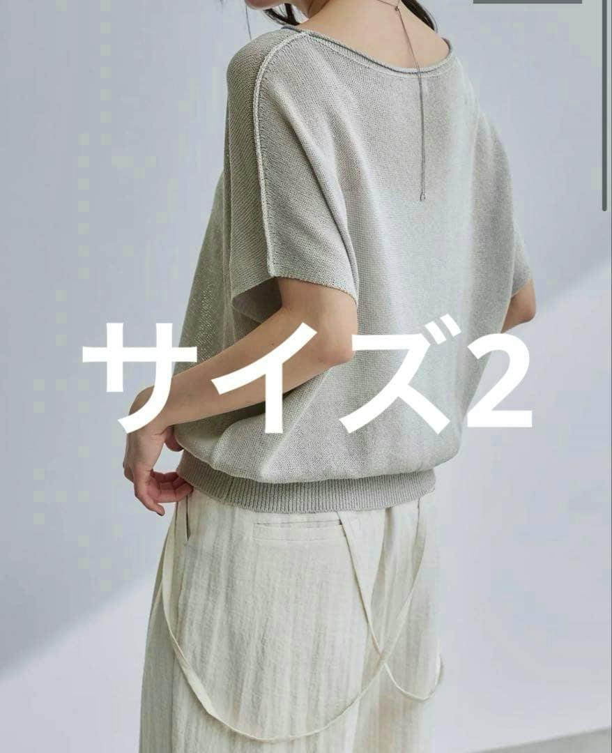 Back view of a model wearing a light-colored dolman knit sweater (rayon) with short sleeves.