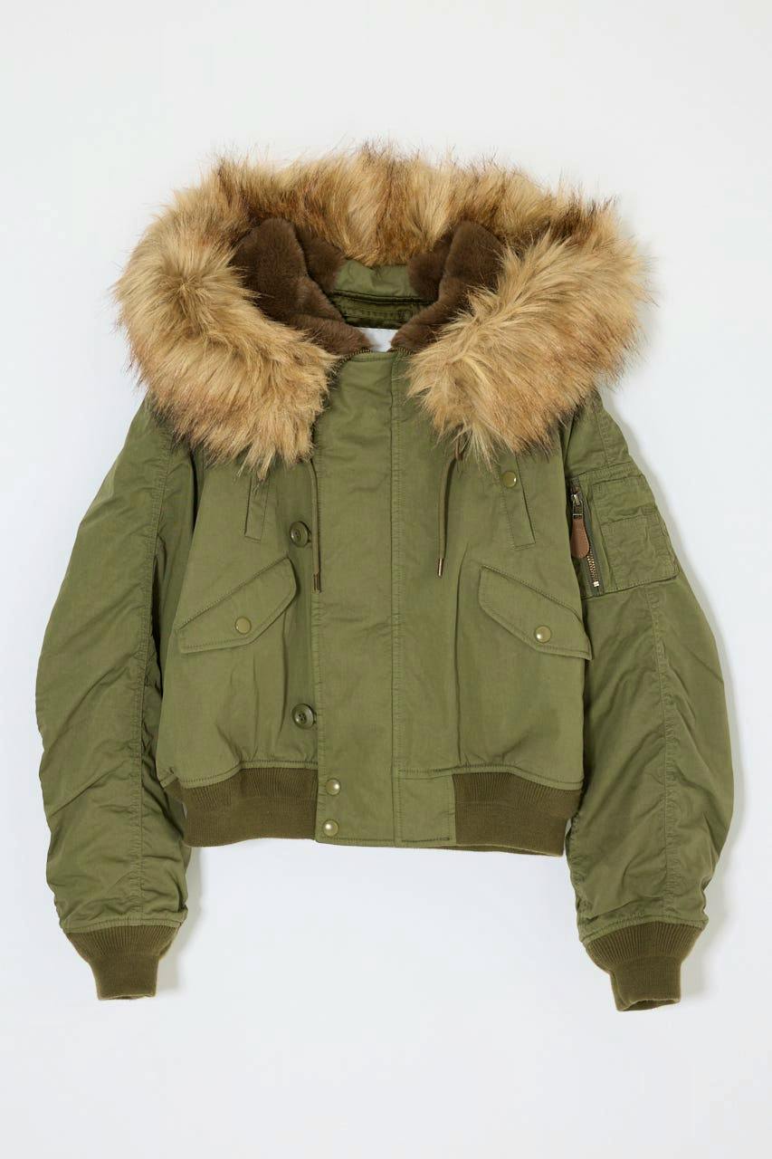 A cropped women's jacket in olive green with a fur-trimmed hood, flap pockets, and ribbed cuffs and hem displayed flat on a white background.