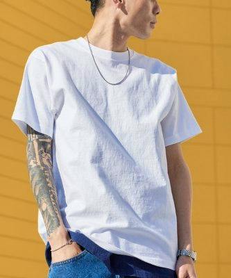 Person wearing a plain white short-sleeve crew-neck T-shirt against a yellow background.