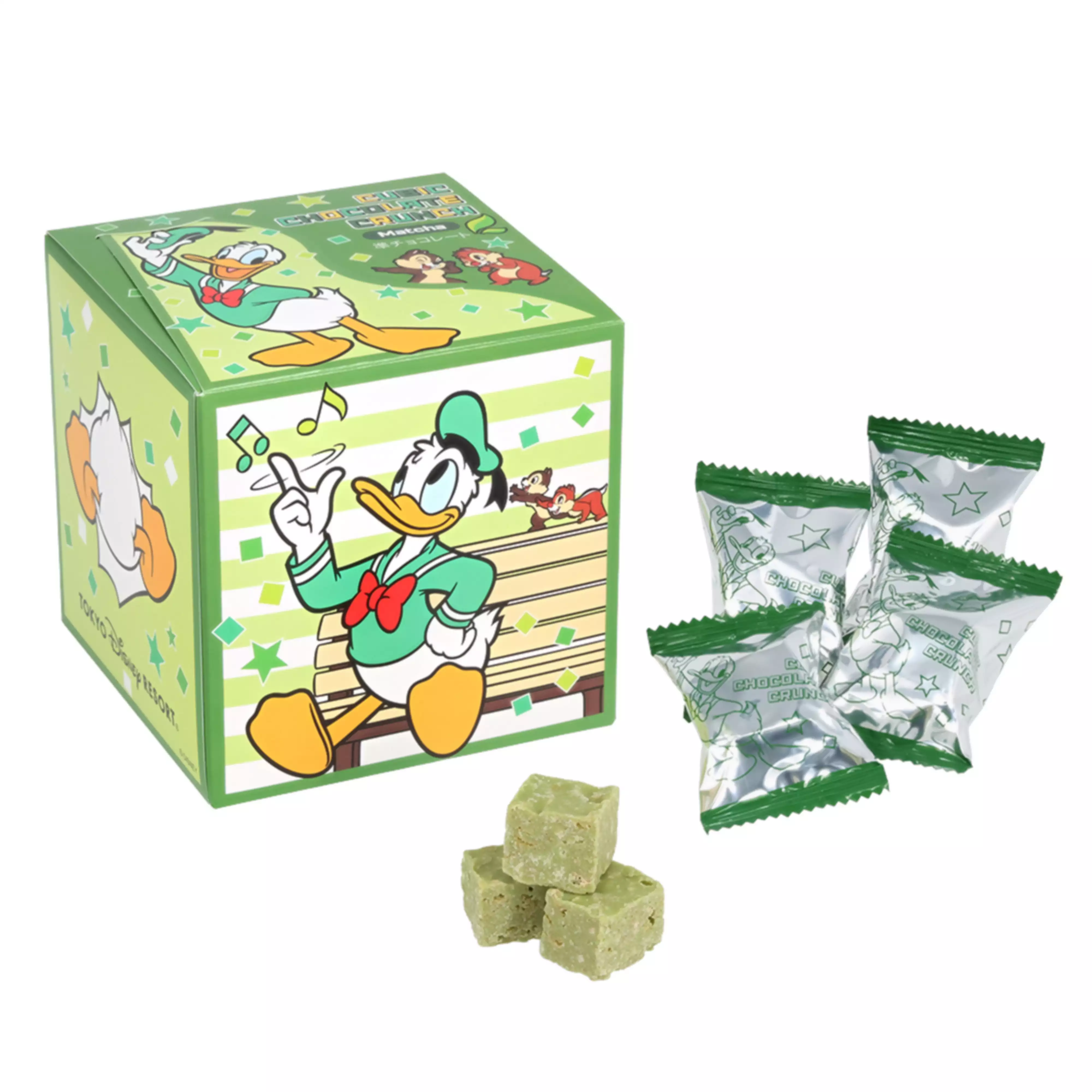 A green cubic paper box decorated with Donald Duck and Chip & Dale, with foil-wrapped individual chocolates and three cube-shaped chocolate crunch pieces displayed.
