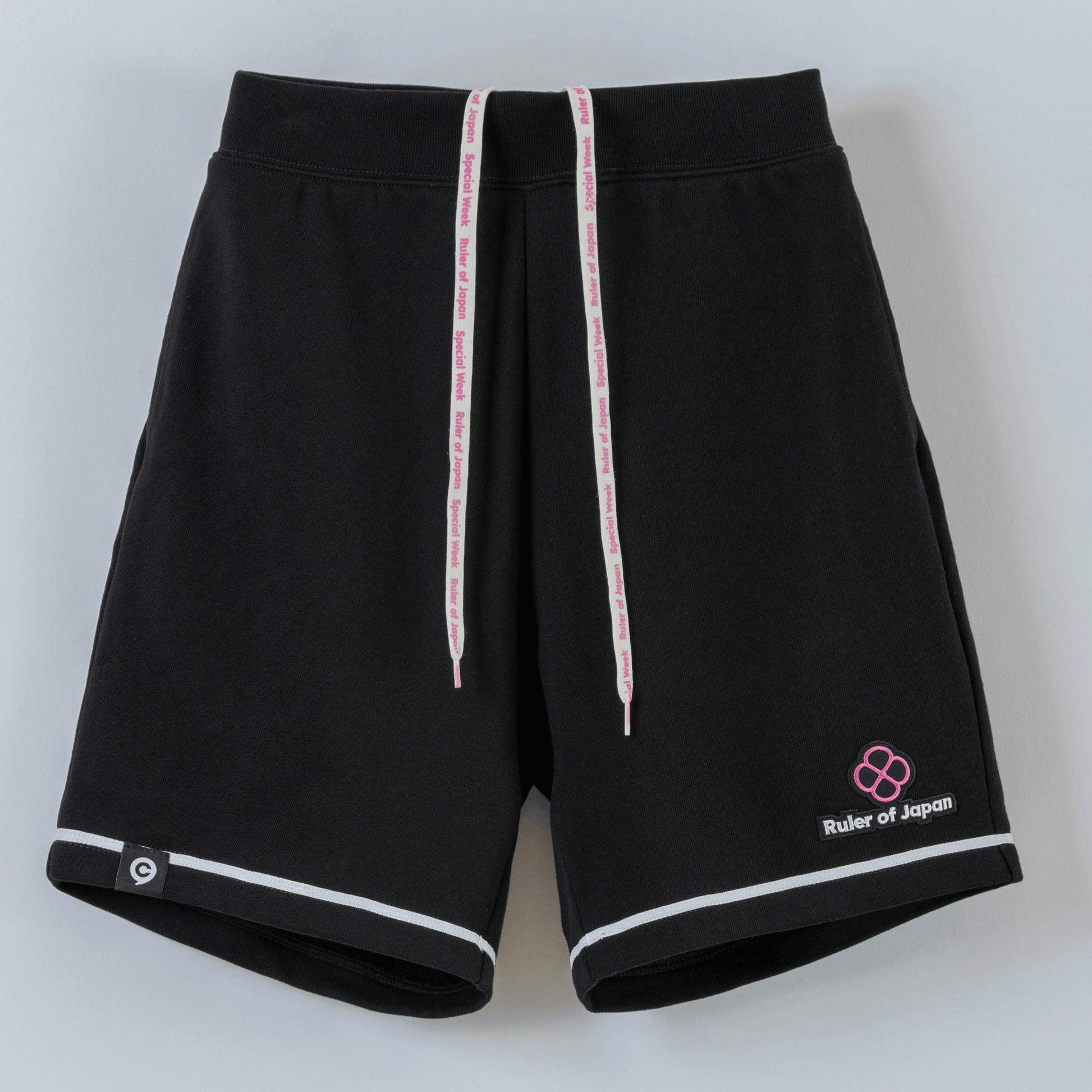 Front view of black men's cotton sweat shorts shown flat with white-and-pink drawstrings, contrast piping at the hems, and a small "Ruler of Japan" patch.