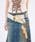 A synthetic-leather crown-buckle feather belt worn around a model's waist over denim jeans.
