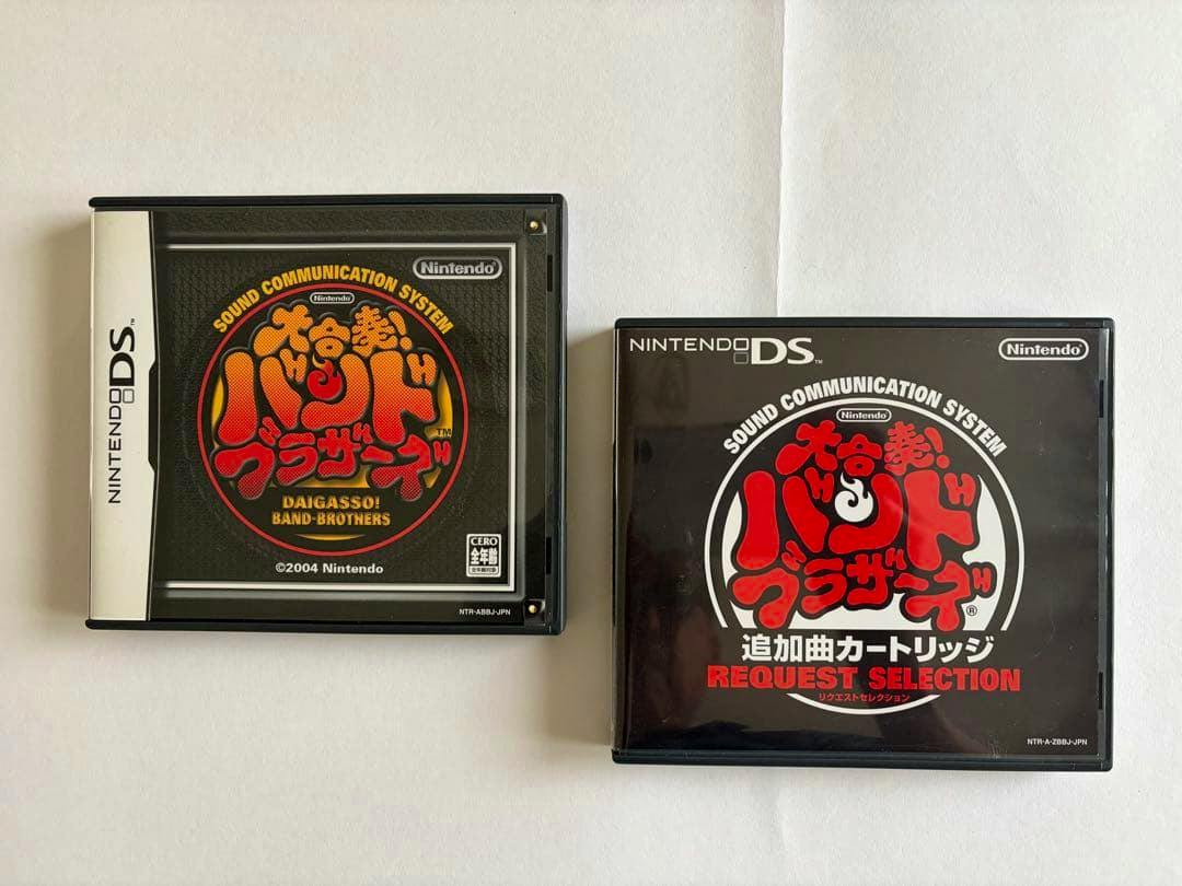 Two Nintendo DS cartridge cases for Daigasso! Band Brothers and the Request Selection additional-song cartridge shown on a white background.