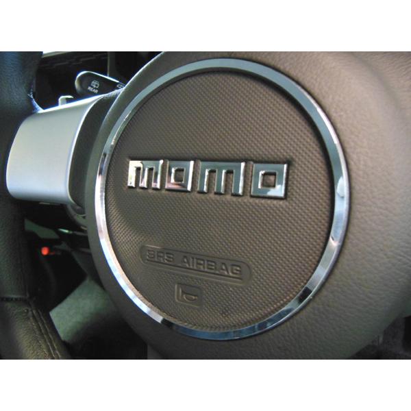 Close-up of a steering wheel center with a chrome MOMO steering center ring installed.