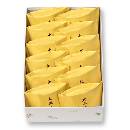 White box containing twelve individually wrapped yellow packages of 大平原 cakes.