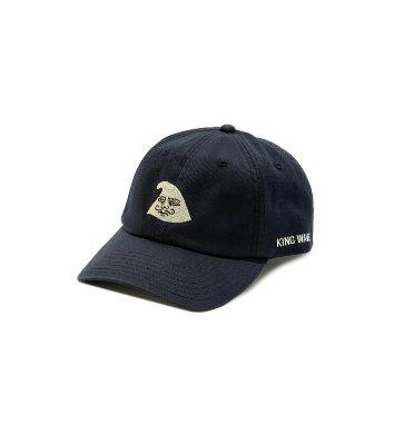 Front three-quarter view of the DAIKANYAMA Graphic Cap, a dark navy cotton baseball cap with a small embroidered graphic on the front and text on the side, shown on a white background.