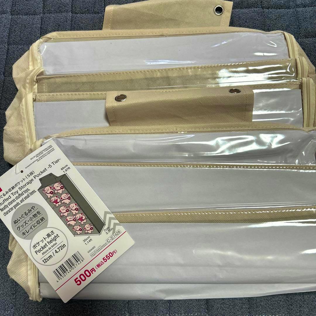 Beige 5-tier stuffed toy storage pocket with clear front panels and a product tag showing the price.