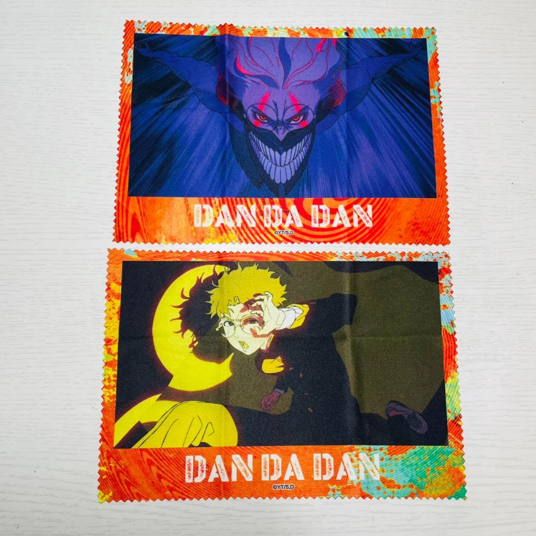 Two polyester multi-cleaner cloths (handkerchiefs) printed with DAN DA DAN character designs laid flat on a white surface.