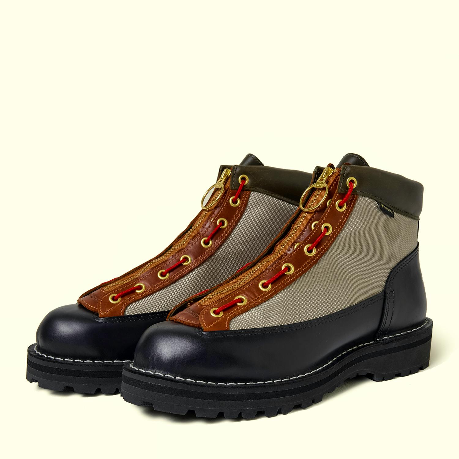 Pair of Danner leather boots showing tan fabric uppers, brown leather eyelet panels with red laces, and black lug soles.