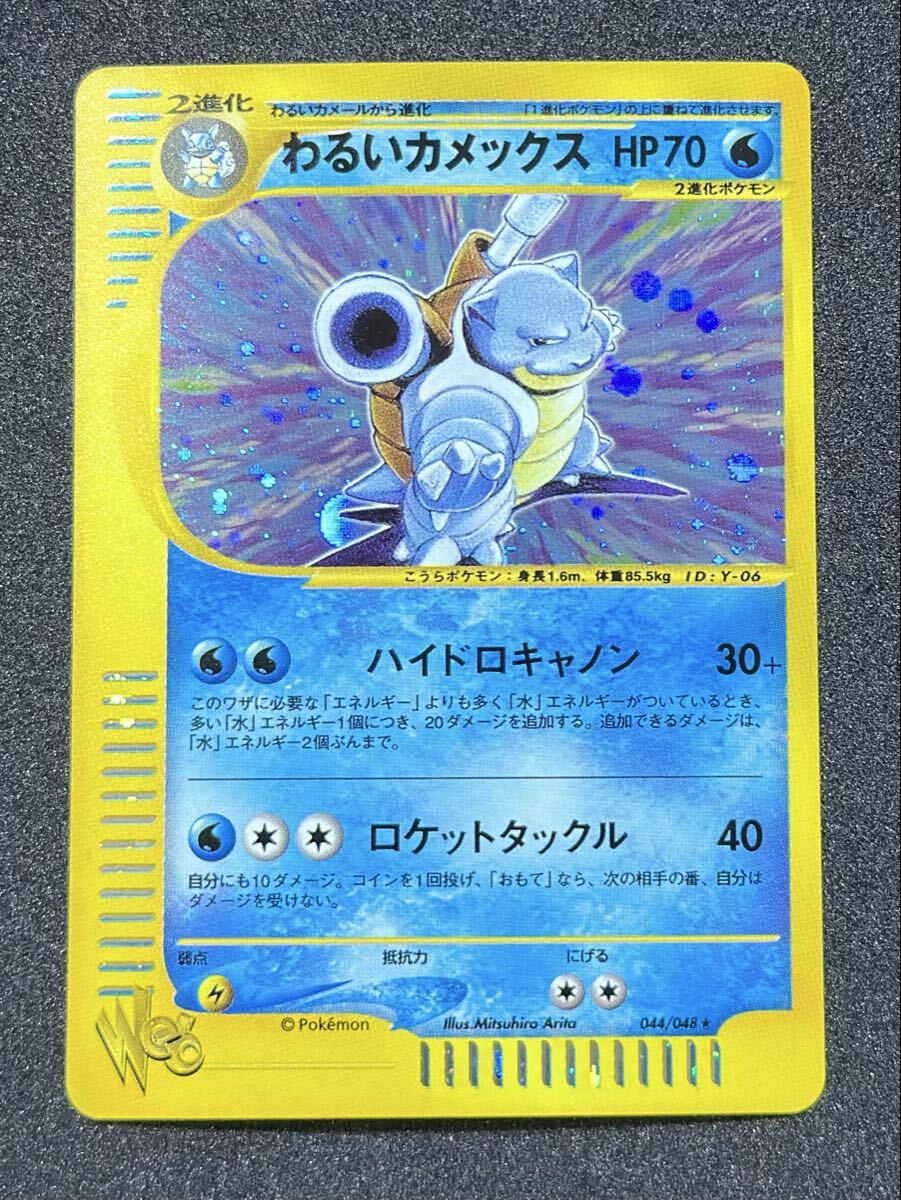 Photograph of the Japanese Pokémon trading card わるいカメックス showing holographic art and a yellow border.