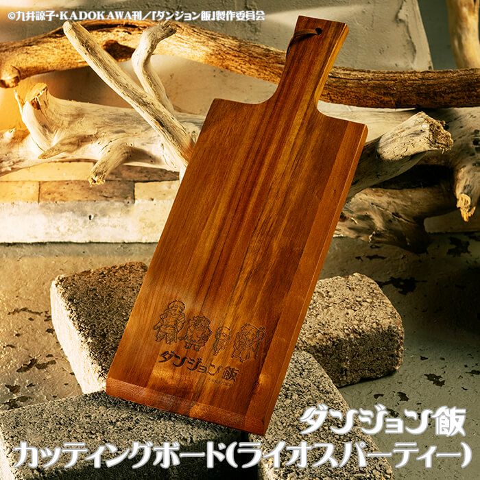 Bamboo cutting board engraved with 『ダンジョン飯』 characters and logo shown on a rustic stone and wood background.