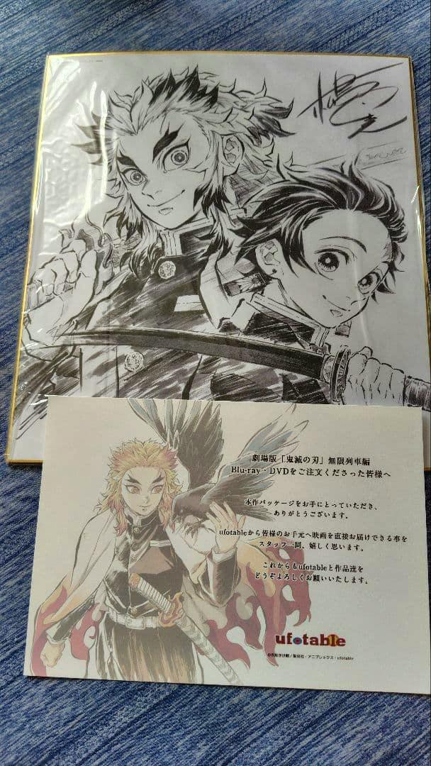 Front of the Demon Slayer: Mugen Train ufotable bonus shikishi showing a black-and-white illustration of two characters with a colored ufotable insert placed at the bottom.
