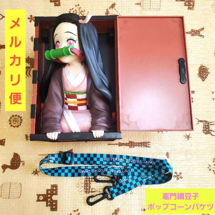 USJ limited Nezuko popcorn bucket placed in an open box with a blue-and-black Universal Studios Japan lanyard visible.