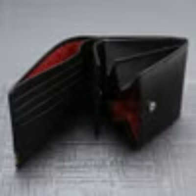 Open black bi-fold cow leather wallet with red interior and visible card slots.