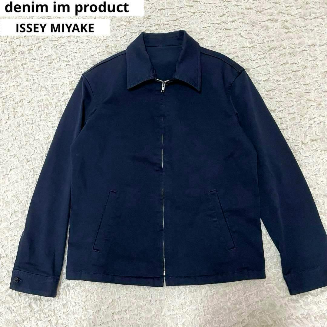 Navy cotton men's zip-up jacket laid flat on a textured surface, showing front and collar.