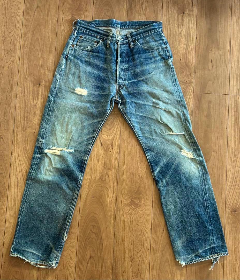 Front view of DENIME men's straight denim jeans laid flat on a wooden floor.