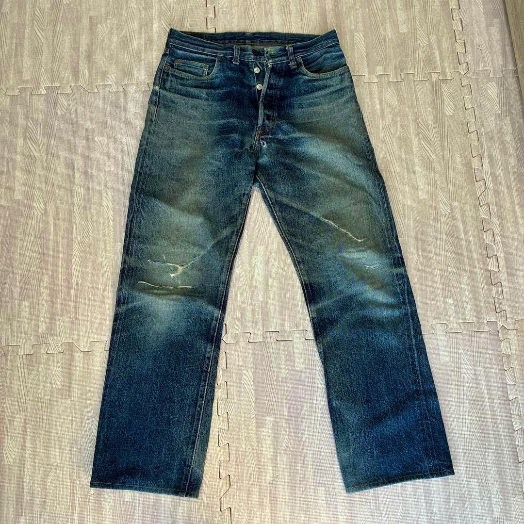 Front view of the men's denim jeans laid flat showing faded color and wear marks.