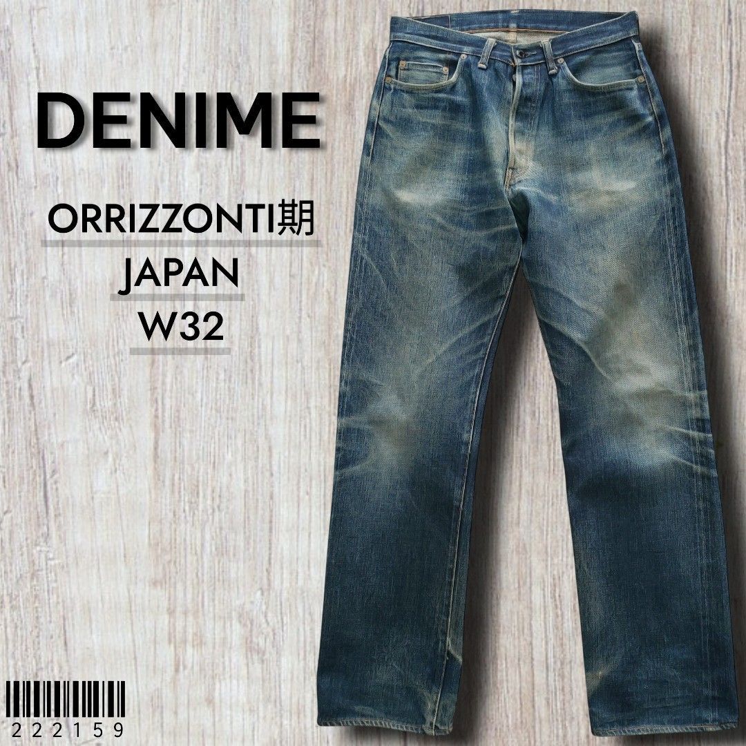 A pair of Denime men's blue denim jeans laid flat showing the front with faded whiskering and wear marks.