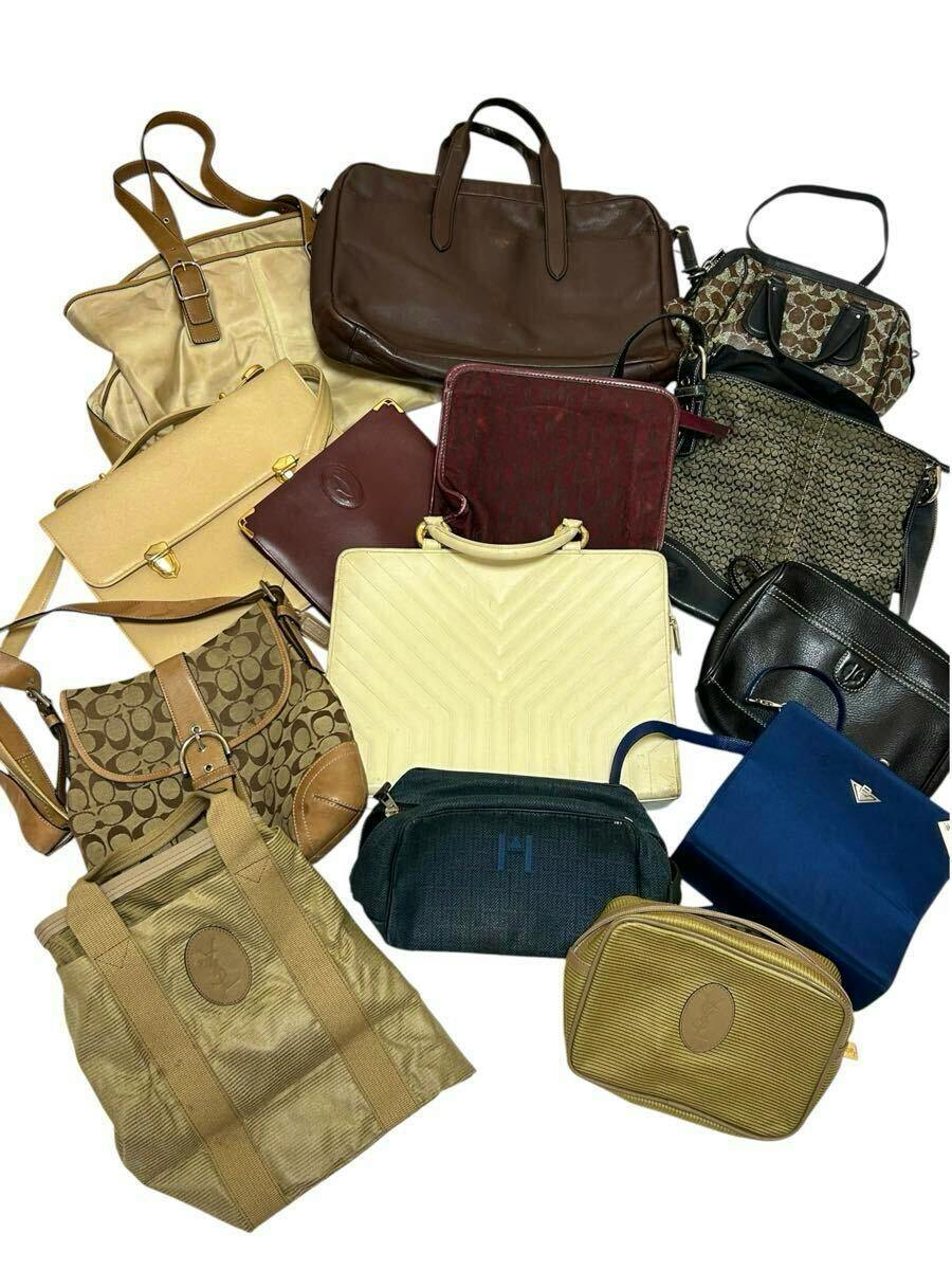 A top-down photo of a collection of assorted branded bags (including COACH) arranged on a white background.