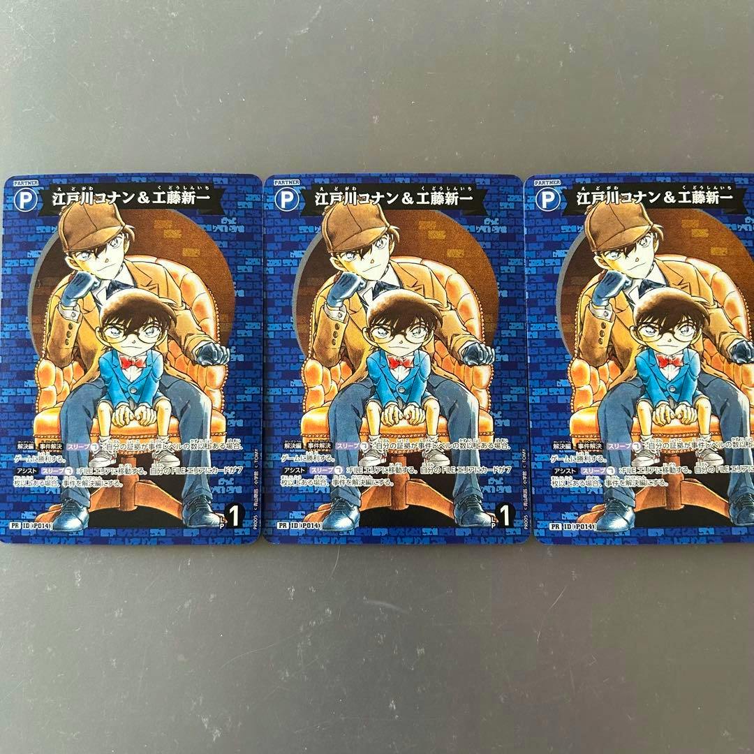 Three identical promotional trading cards showing Edogawa Conan and Kudo Shinichi artwork laid side-by-side on a gray surface.