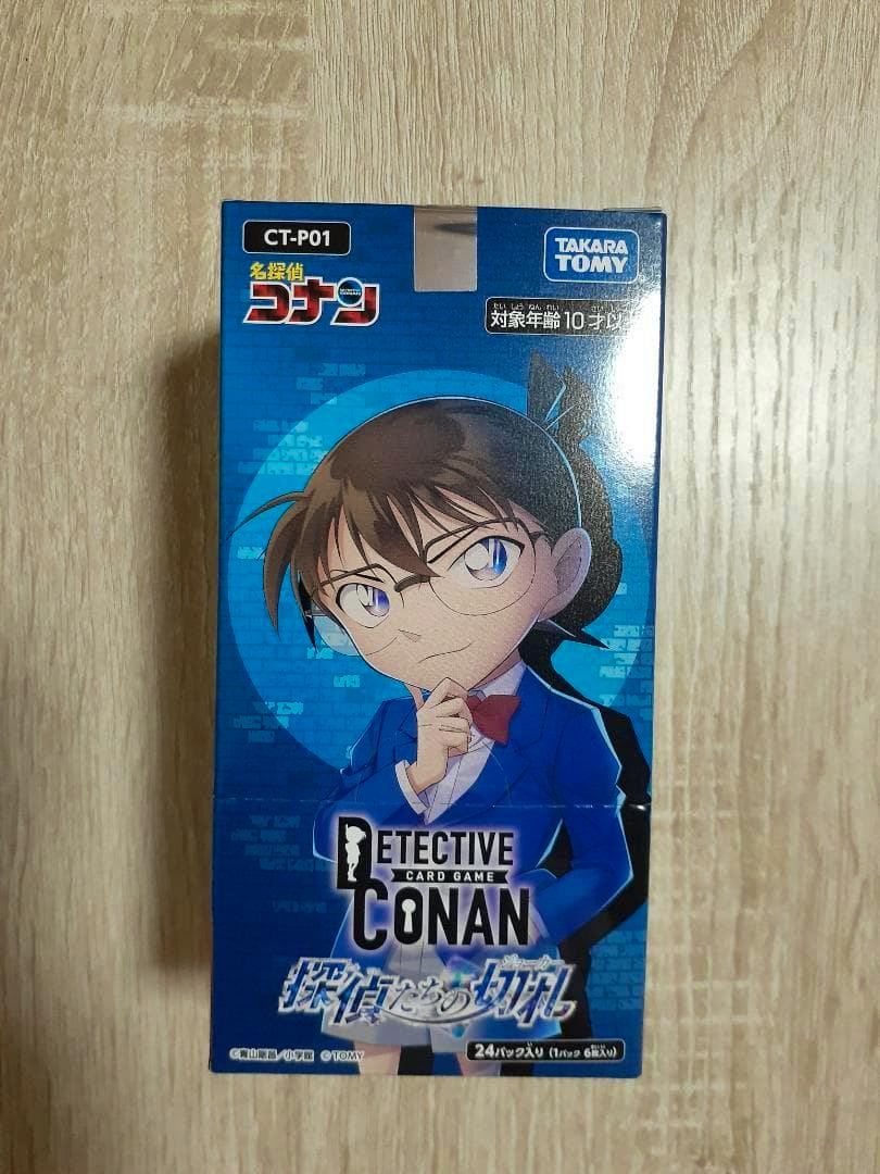 Front view of a Detective Conan card game booster box (unopened) showing blue packaging with Conan character artwork.
