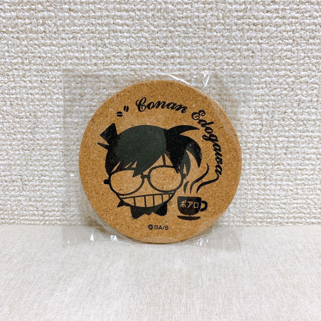Round cork coaster showing a printed stylized Conan Edogawa face, the text "Conan Edogawa", and a steaming coffee cup graphic, sealed in plastic.