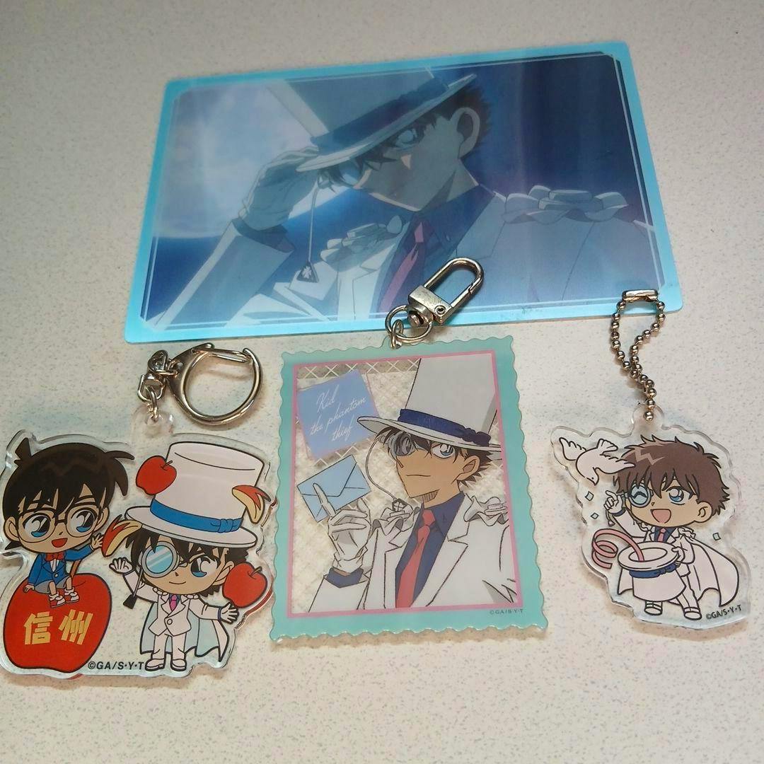 Three acrylic keychains of Detective Conan / Kaito Kid characters displayed on a table with two illustrated cards.