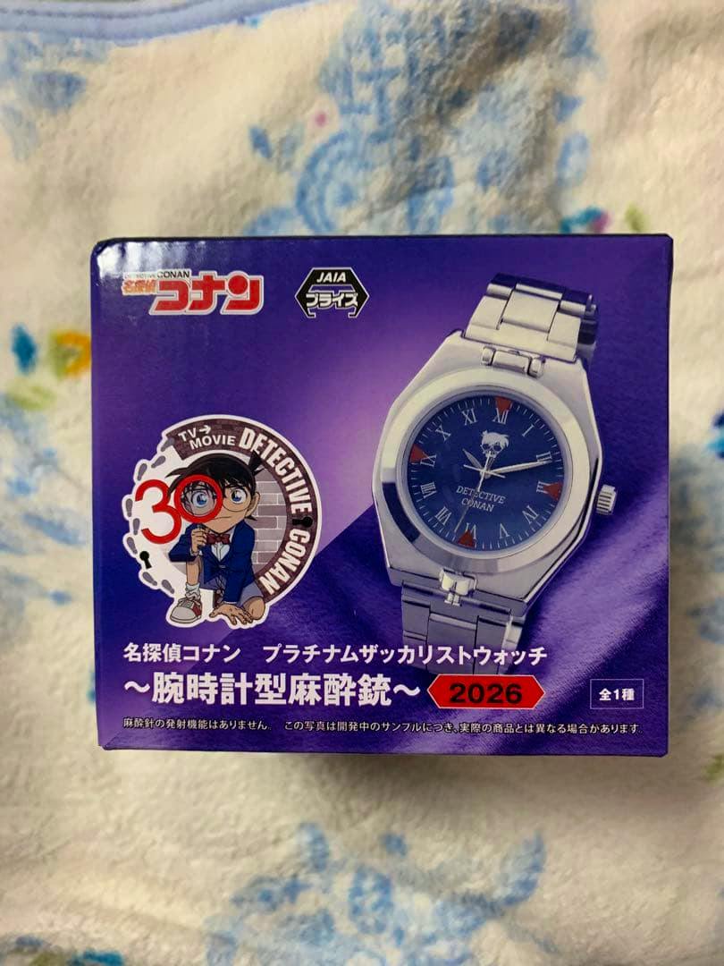 Photo of the product's purple retail box showing a Detective Conan platinum wristwatch illustration and branding.