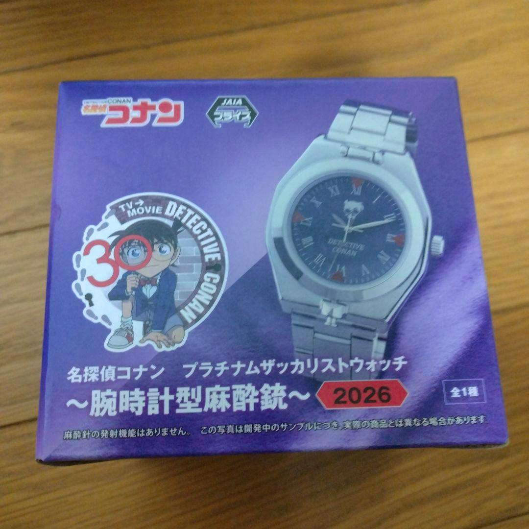 Photo of the Detective Conan product box showing printed image of the metal wristwatch-shaped toy and Conan character artwork.