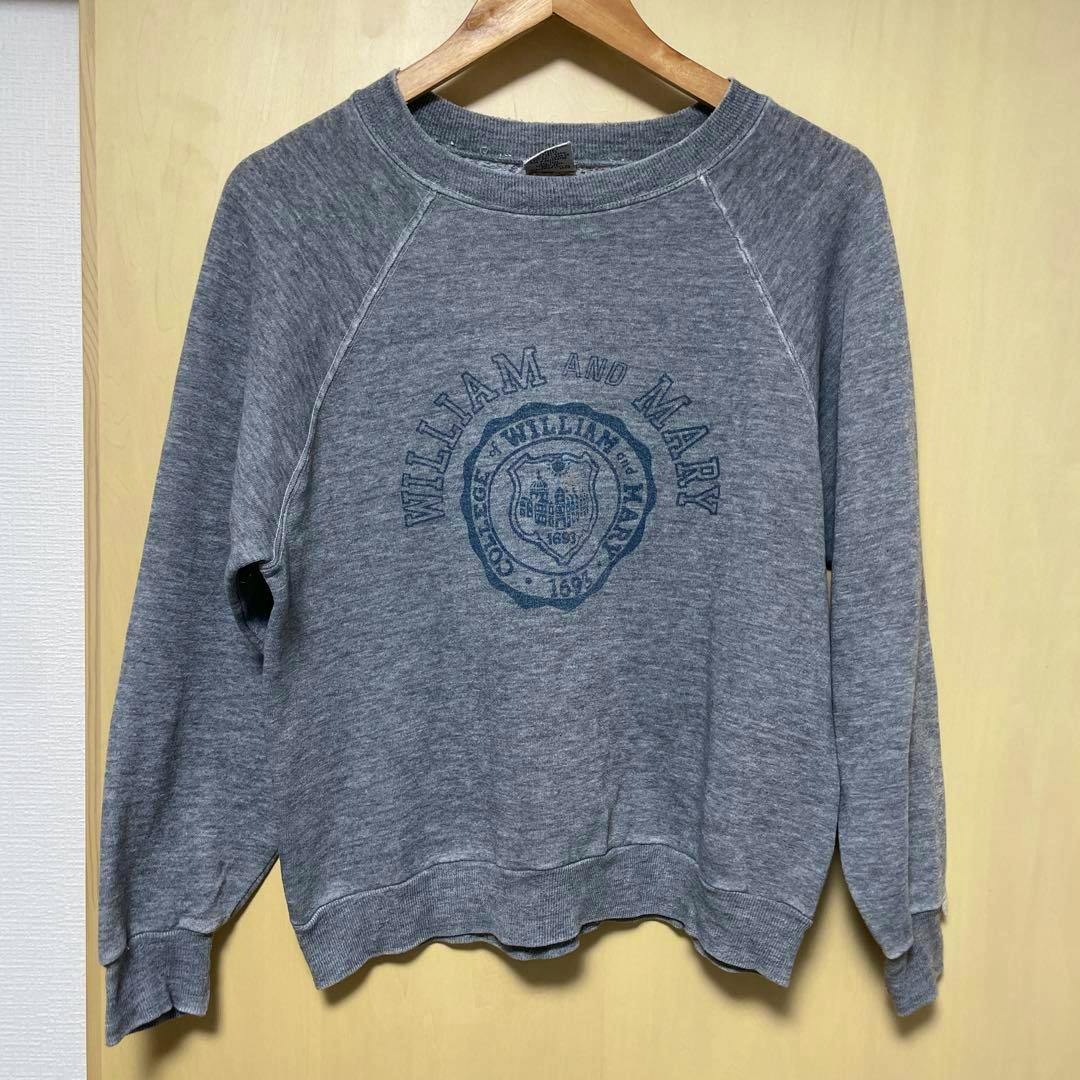 Gray Dickies sweatshirt with a circular crest graphic on the front, hanging on a wooden hanger against a light background.
