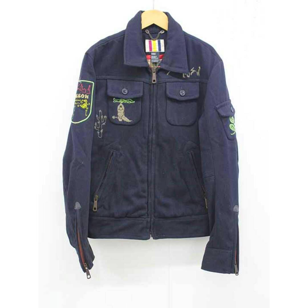 Front view of a navy women's jacket with embroidered patches hanging on a hanger.