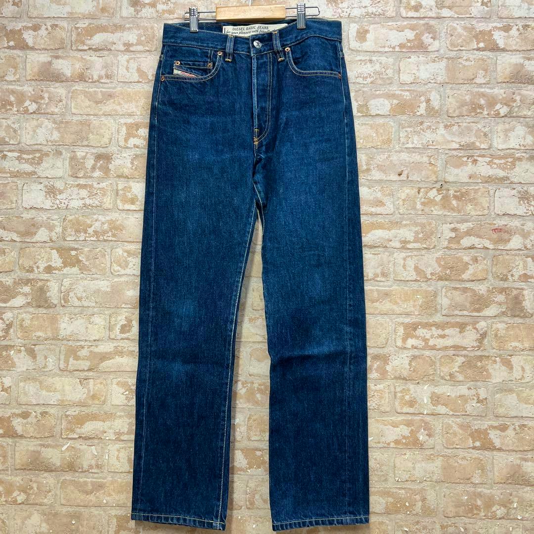 Full-length indigo Diesel straight women's jeans (W29) hanging against a brick wall.