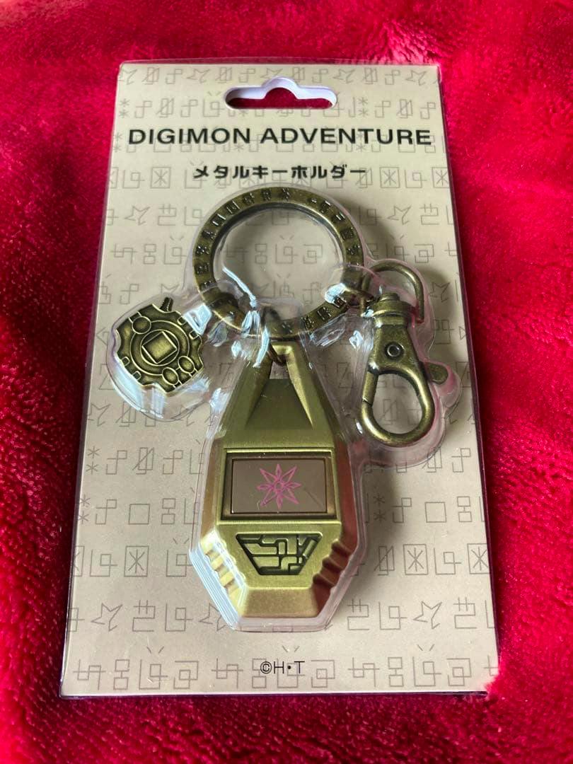 Front view of the packaged Digimon Adventure metal key holder (Light Crest) bag charm in blister packaging.