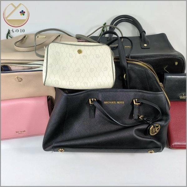 Multiple handbags and wallets arranged together, with a black Michael Kors bag prominent in front.