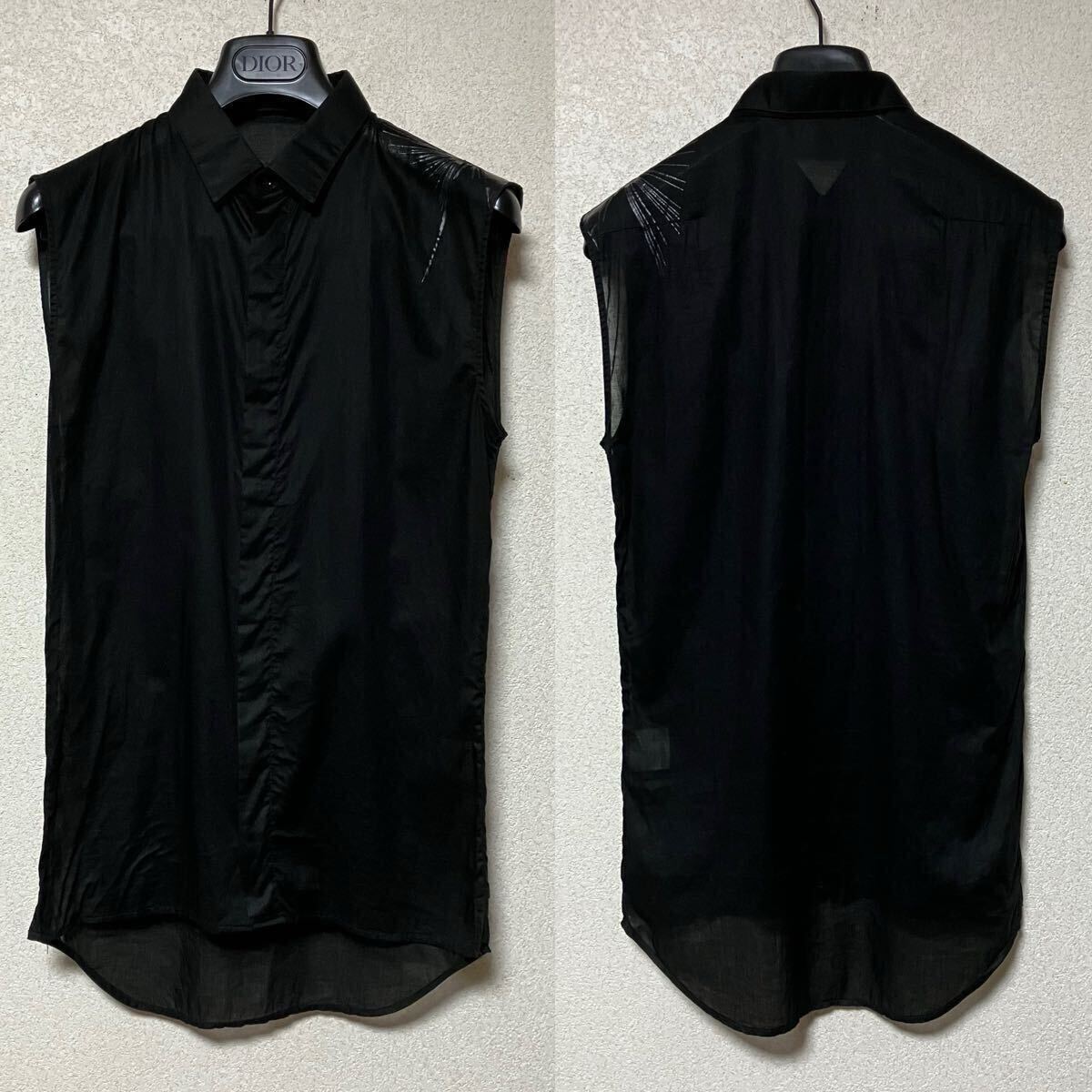 Front and back views of a black sleeveless women's blouse (Dior Homme) hanging on a hanger.