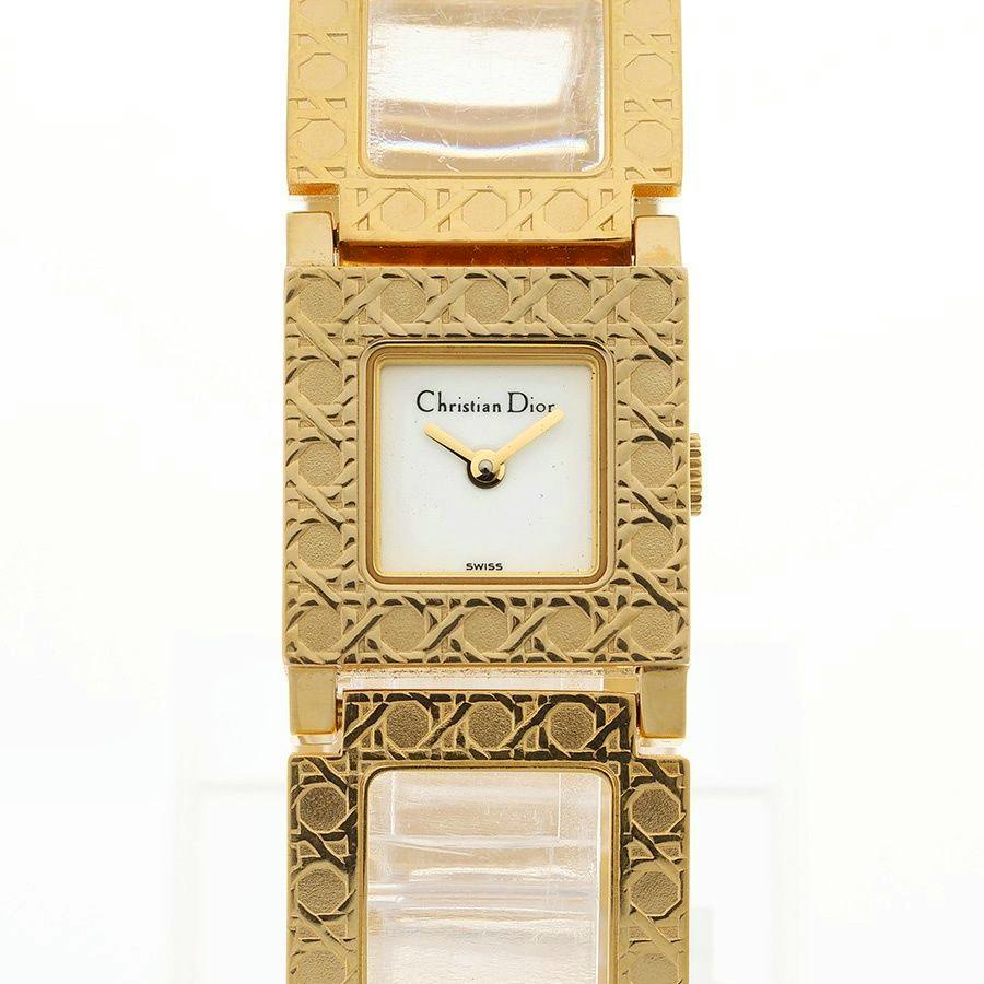 Close-up front view of a gold Christian Dior La Parisienne women's quartz wristwatch showing the square dial and patterned bracelet.