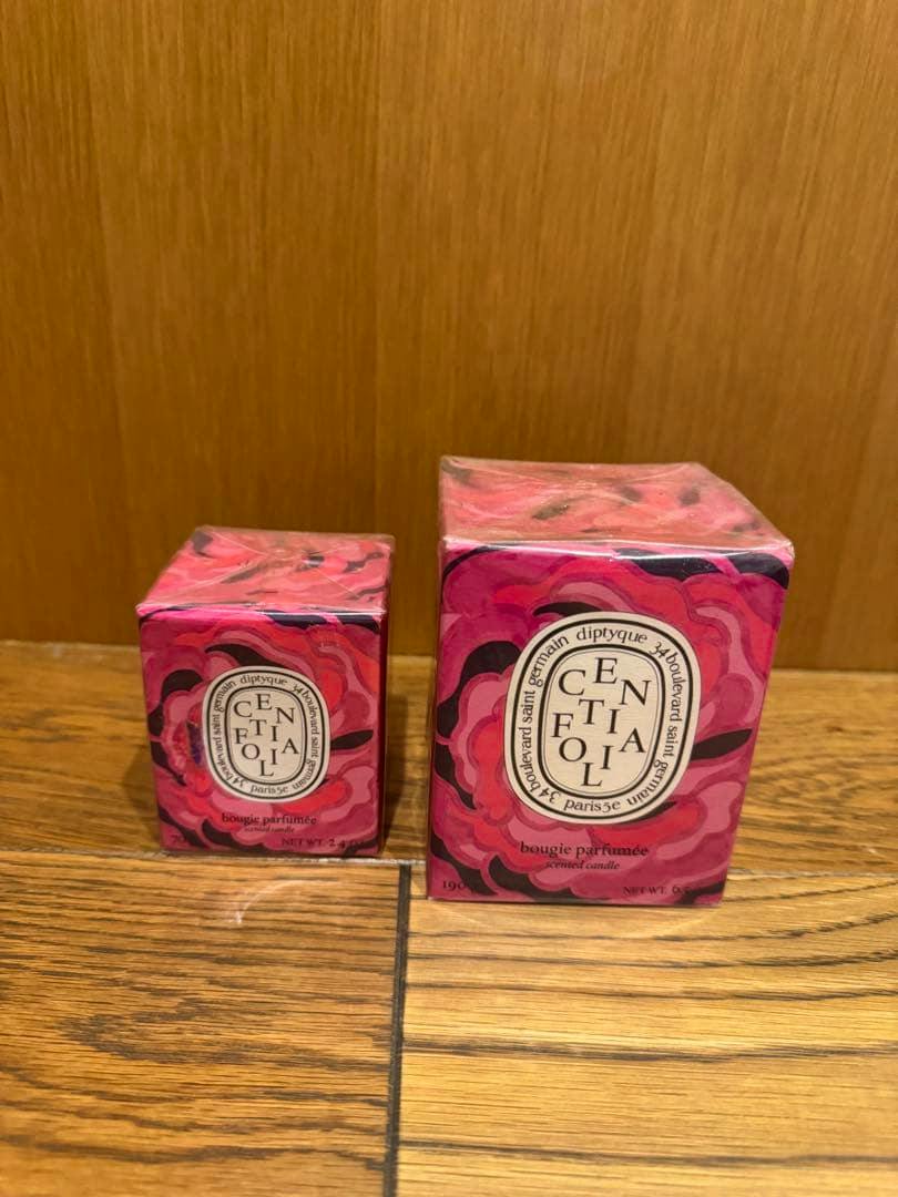 Two boxed diptyque Centifolia candles (70g and 190g) in pink patterned packaging on a wooden surface against a wooden background.