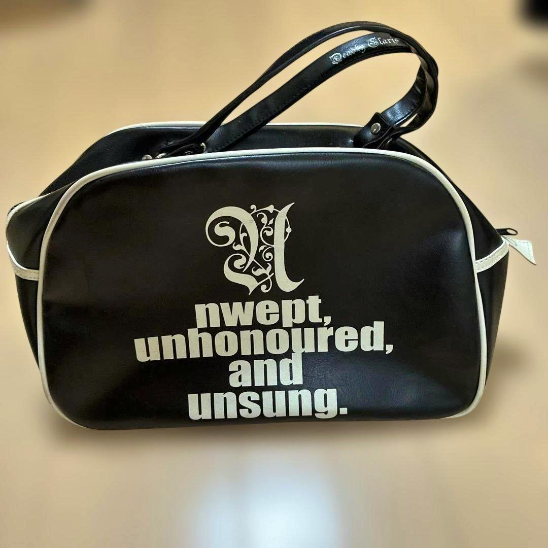 A black ディルアングレイ goods bag with white piping and white printed text on the front.