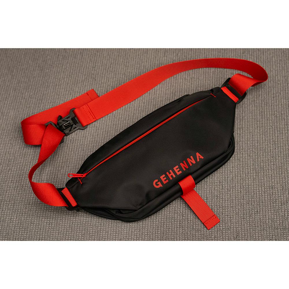 Black polyester shoulder bag with red straps and red "GEHENNA" logo shown lying flat on a gray surface.