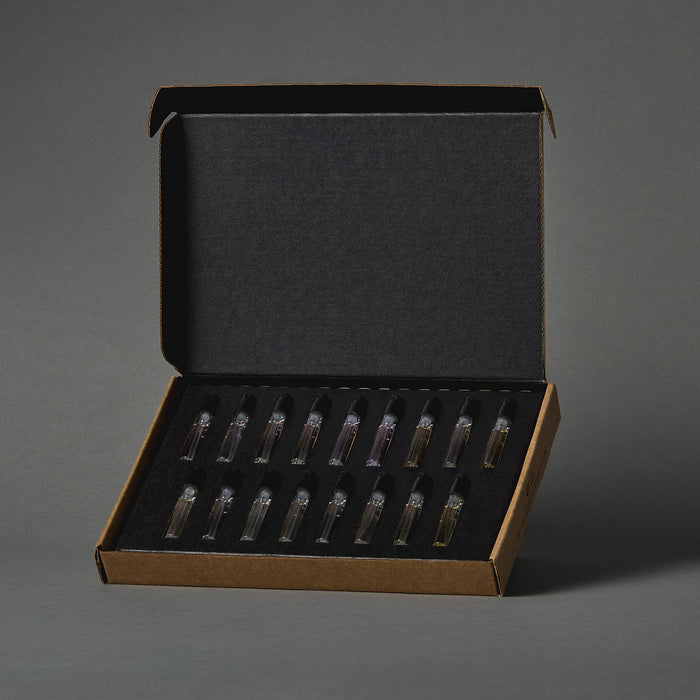 Open discovery set box containing multiple small perfume sample vials neatly arranged in a foam insert.
